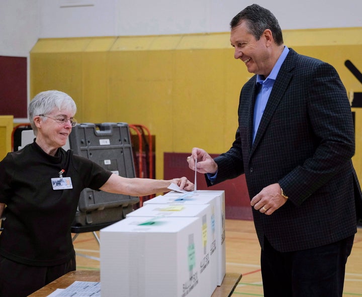 Calgary mayoral candidate Bill Smith, right, casts his vote in the municipal election at a polling station in Calgary, Alta., Monday, Oct. 16, 2017.