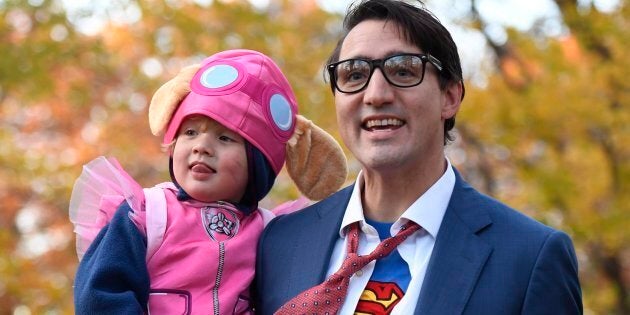 Prime Minister Justin Trudeau, dressed as Clark Kent, holds his son Hadrien, dressed as Skye from