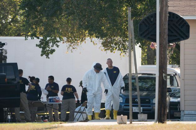 FBI officers walk behind the First Baptist Church of Sutherland Springs after a fatal shooting on Nov. 5, 2017, in Sutherland Springs, Texas.