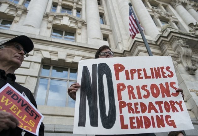 Protesters from DC Divest hold up signs during a Divest the Globe demonstration in Washington DC on Oct. 23, 2017.