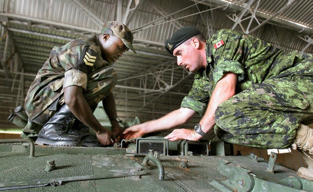 A Canadian soldier, right, works with a Rwandan African Union peacekeeper during an unrelated Canadian-led training course for African troops near Thies, Senegal on Sept. 9, 2005. File photo.