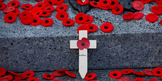 A wooden cross is surrounded by poppies on the Tomb of the Unknown Soldier following Remembrance Day ceremonies at the National War Memorial in Ottawa on Nov. 11, 2017.