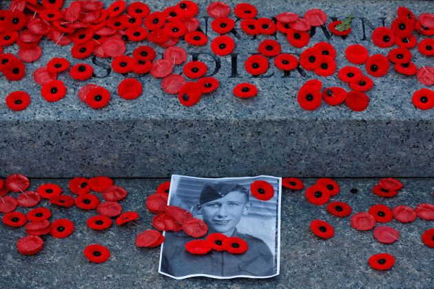 A photograph is surrounded by poppies placed on the Tomb of the Unknown Soldier following Remembrance Day ceremonies at the National War Memorial.