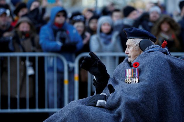 A veteran waves to the crowd as he arrives for Remembrance Day ceremonies at the National War Memorial.