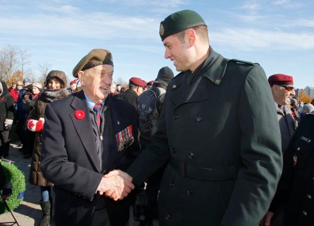 Master Corporal Andrew White speaks with Jack Commerford, 93, a veteran who landed on Juno Beach in World War II, at the National Military Cemetery.