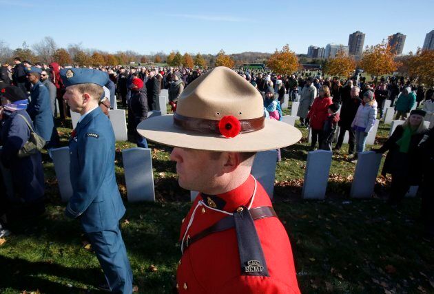 A Mountie wearing a poppy stands at attention at the National Military Cemetery during a ceremony on Remembrance Day in Ottawa.