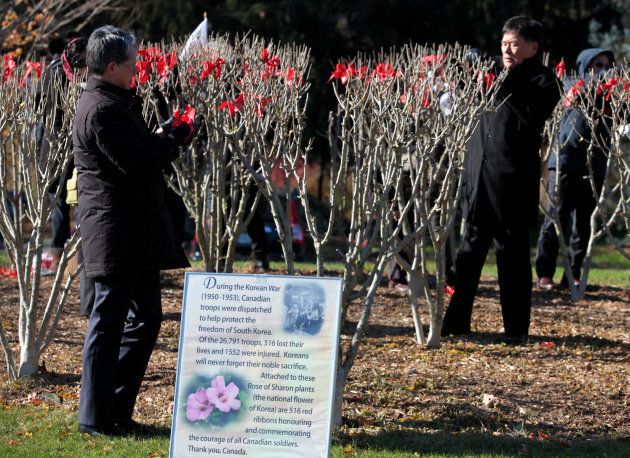 Participants tie red ribbons on Rose of Sharon trees in honor of 516 Canadian troops who lost their lives in the Korean War (1950-1953) ahead of Remembrance Day on Nov. 10, 2017.