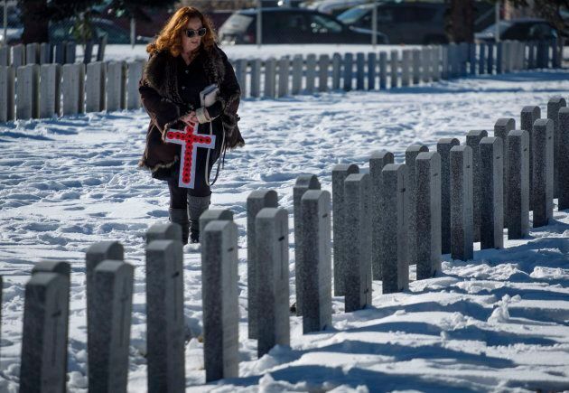 Lyn Moehling looks for the grave marker of her grandfather, WWI veteran Noble Edgar Taggart, following a Remembrance Day service in Calgary.