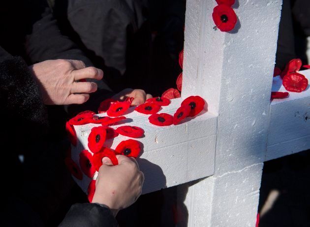 Poppies are placed on a cross during Remembrance Day ceremonies at the Grand Parade in Halifax.