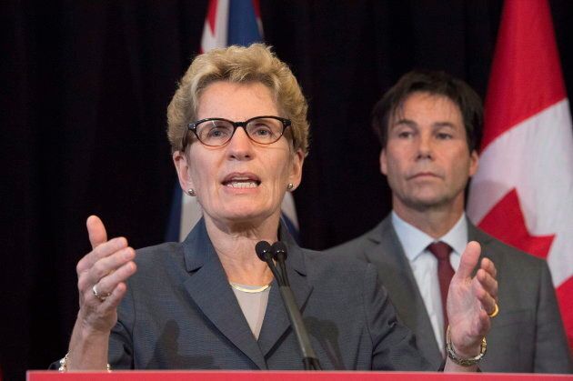 Ontario Premier Kathleen Wynne speaks as Health Minister Eric Hoskins looks on in Toronto on Oct. 20, 2014.