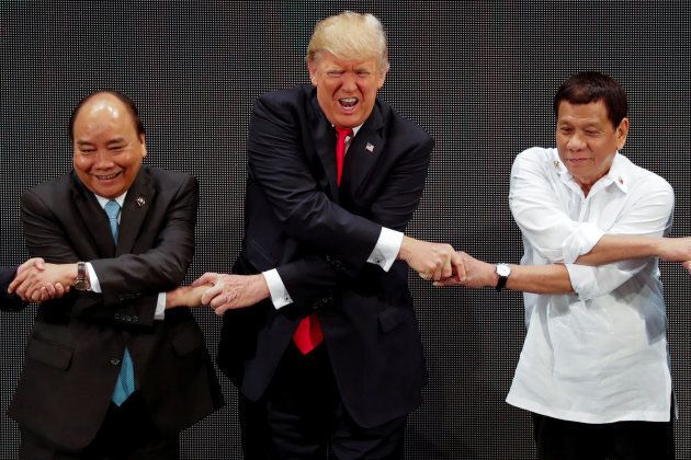 U.S. President Donald Trump, Vietnam's Prime Minister Nguyen Xuan Phuc and Philippines President Rodrigo Duterte perform the group "ASEAN handshake" in the opening ceremony of the ASEAN Summit in Manila on Nov. 13, 2017.