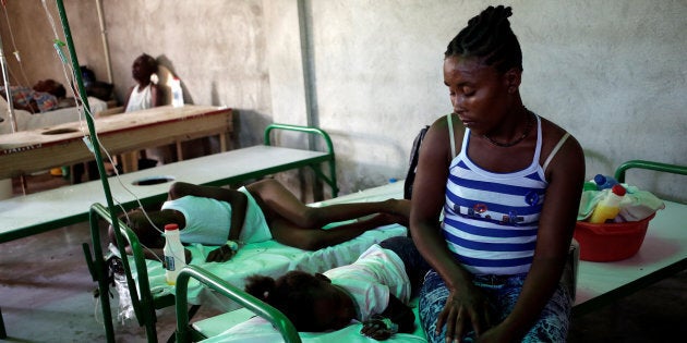 A woman sits next to her daughter as she receives treatment for cholera at the Immaculate Conception Hospital in Les Cayes, Haiti, Nov. 8, 2016.