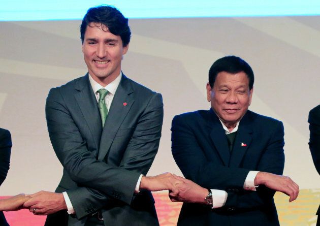 Philippines' President Rodrigo Duterte holds hands with Canada Prime Minister Justin Trudeau for a family photo during the ASEAN-Canada 40th anniversary commerative summit in metro Manila, Philippines, Nov. 14, 2017.