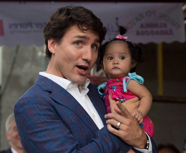 Canadian Prime Minister Justin Trudeau holds a young baby as he visits the Likhaan Women's Health centre in Manila, Philippines on Nov. 12, 2017.