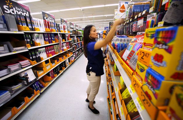 Walmart department manager Karren Gomes helps stock shelves with school supplies as the retail store prepares for back to school shoppers in San Diego, Calif., Aug. 6, 2015.