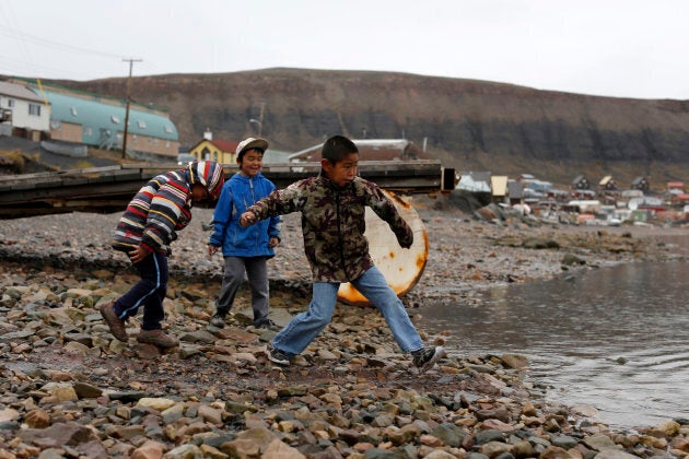 Young boys skip stones in the Arctic community of Arctic Bay in Nunavut.