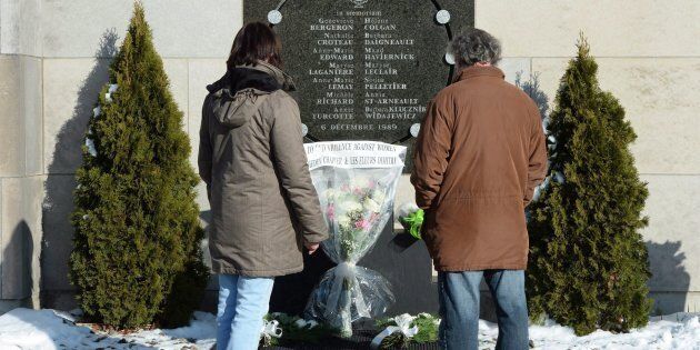People stop at the memorial plaque in honour of the 13 students and one staff member killed in the Polytechnique massacre in Montreal on Dec. 6, 2016.