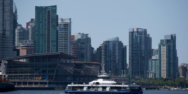 A Seabus commuter vessel with condo towers in the background in Vancouver, B.C., Tuesday, July 11, 2017. The city of Vancouver is considering restricting ownership of housing to local residents.