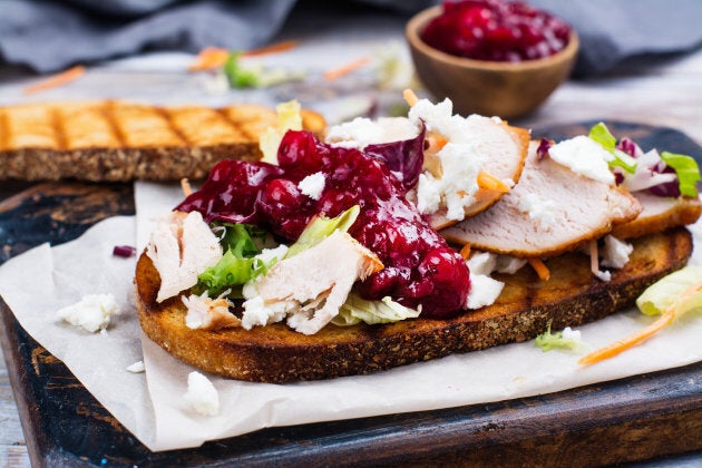 Homemade leftover thanksgiving day sandwich with turkey, cranberry sauce, feta cheese and vegetables