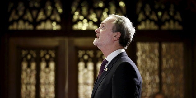 Andre Pratte looks up while waiting in the entrance of the Senate chamber before being sworn-in as a senator on Parliament Hill in Ottawa on April 12, 2016.