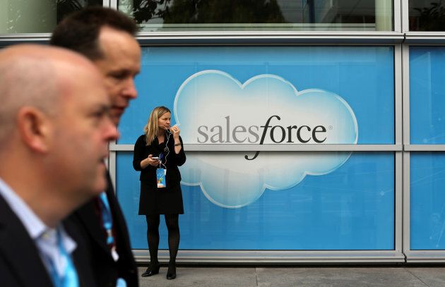 A woman stands near a Salesforce sign during the company's annual Dreamforce event, in San Francisco Nov. 18, 2013.