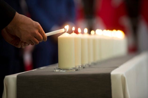 Liberal MP Shaun Chen lights a candle during a commemorative ceremony for the victims of Polytechnique at the Consulate General of Canada in Guangzhou, China on Dec. 6, 2017.