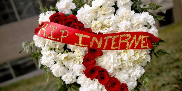 A funeral flower arrangement is set up outside the Federal Communication Commission building during a protest against the end of net neutrality rules on Thursday.