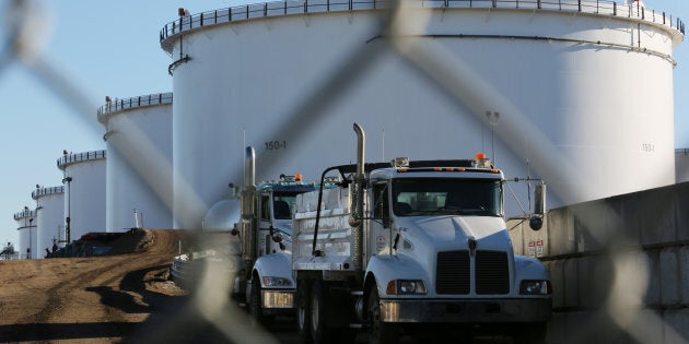 Dump trucks parked near crude oil tanks at Kinder Morgan's North 40 terminal project in Sherwood Park, near Edmonton, Alta. on Nov. 13, 2016. Canadian oil prices have plunged amid a supply glut.