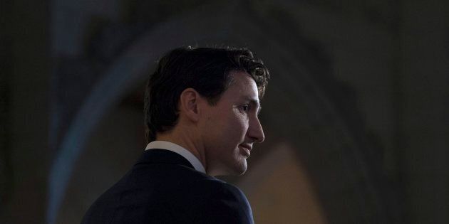 Prime Minister Justin Trudeau listens to a question from the media in the foyer of the House of Commons following the release of an ethics report in Ottawa on Dec. 20, 2017.