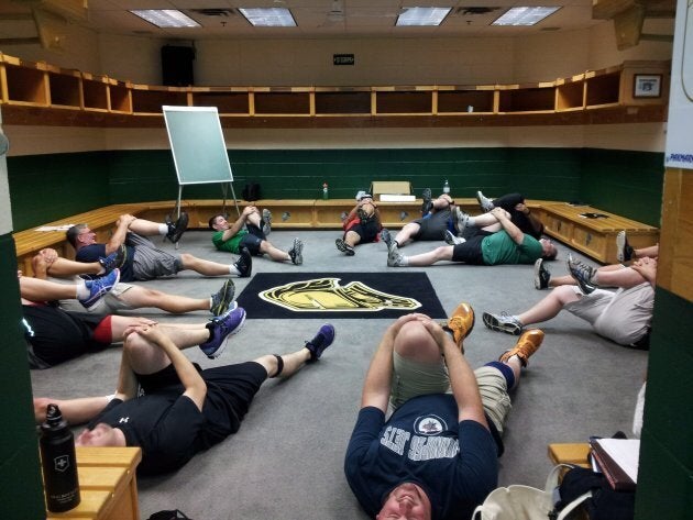 Men participating in the University of Western Ontario's Hockey Fans In Training program, funded by the Movember Foundation, stretch in the London Knights locker room.