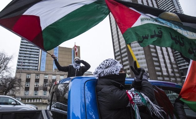 Protesters wave Palestinian flags in Toronto on Dec. 9, 2017, as they walk across University Avenue in front of the U.S. consulate, during a demonstration against the recent decision by President Donald Trump to recognize Jerusalem as Israel's capital.