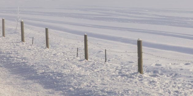 A fence in a snow-covered field in northern Canada.