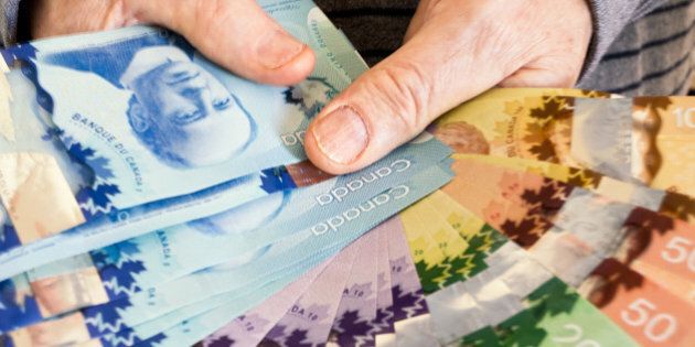 Senior Man Holding Canadian Paper Currency