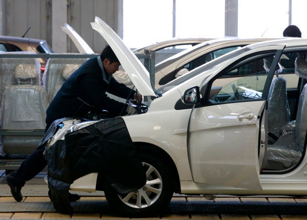 An employee works on an assembly line producing electric cars at a Beijing Electric Vehicle factory, funded by BAIC Group, in Beijing, China, Jan. 18, 2016.