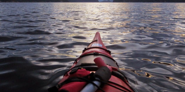 This photo taken Aug. 15, 2014 shows the view at dusk shows a sunset kayak outing, along the Saguenay fjords near Tadoussac, Quebec, a lively town visited by more Europeans than Americans. Here, the Saguenay River converges with the mighty St. Lawrence in saline waters frequented by whales. The commanding Saguenay fjords are a playground for hikers, nature lovers and kayakers as well as for cyclists who come from afar to bike Quebec's Route Verte bicycle network. (AP Photo/R.M. Green)