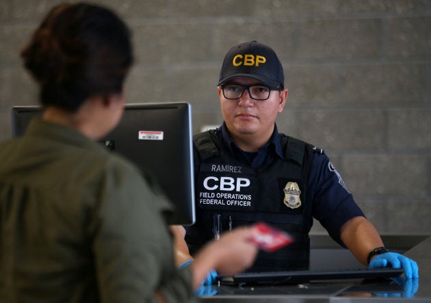 A U.S. Customs and Border Patrol officer interviews people entering the United States from Mexico at the border crossing in San Ysidro, California, on Oct. 14, 2016.