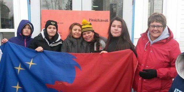 Noretta Miswaggon, third from right, and Pimicikamak Chief Cathy Merrick, far right, hold a Pimicikamak flag with teenagers Cherish Blacksmith, Theodra Thomas, Athena Gamblin and Bethany Ross, at Jenpeg Generating Station in northern Manitoba in 2014.