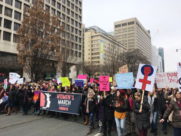 Thousands of people, many wearing pink hats, chanted, cheered and held protest signs while listening to speakers in front of Ontario's provincial legislature, Queen's Park, then marched to the U.S. consulate and Toronto's City Hall, in Toronto, Ont., on Jan. 21, 2017.