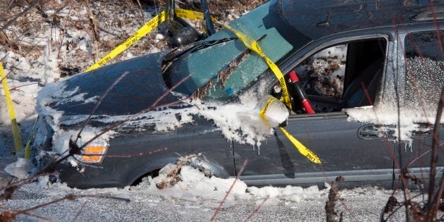 A minivan sits frozen in the water next to Route 101 in Blissville, N.B., on Jan. 14, 2018. Heavy rain flooded the road on Saturday causing poor driving conditions, followed by cold temperatures that froze the water overnight.