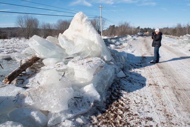 Karen Yorke-Doucette takes a photo of the ice piled up along side of Route 101 in Hoyt, N.B., on Jan. 14, 2018. Heavy rain flooded the road on Saturday floating large ice onto the road and dropping temperatures then froze the water overnight into Sunday morning.