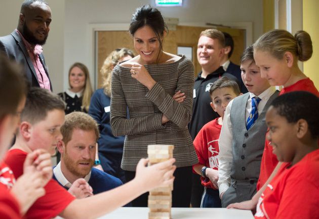 Prince Harry and Meghan Markle watch a game of Jenga during their visit to Star Hub on Jan. 18, in Cardiff, Wales.