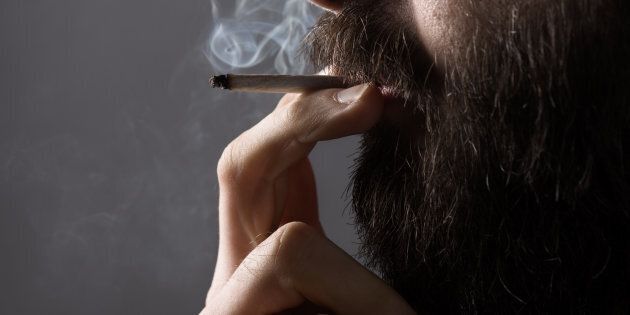 A man is seen smoking a joint.