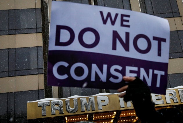 A protester holds a sign up during a #MeToo demonstration outside Trump International hotel in New York City on Dec. 9, 2017.