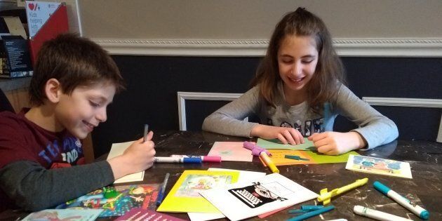 Jeremy and Tamara Cohn, 10, sign cards for
