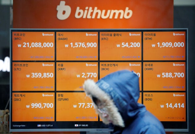 A man walks past an electric board showing exchange rates of various cryptocurrencies at Bithumb cryptocurrencies exchange in Seoul, Jan. 11, 2018.