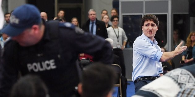 Prime Minister Justin Trudeau argues with a protester as police officers intervene at a public town hall in Nanaimo, B.C. on Feb. 2, 2018.