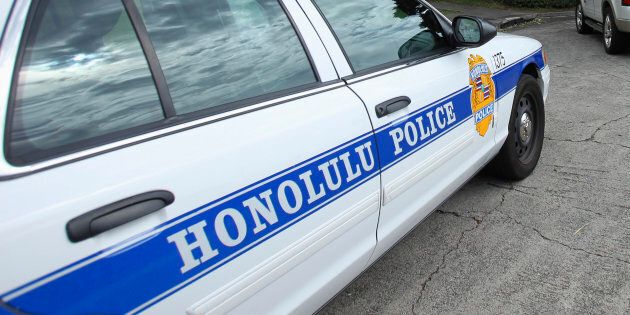 Police cars are seen parked in front of Roosevelt High School after a shooting incident in Hawaii Jan. 28, 2014. The FBI is investigating four Honolulu police officers who are accused of forcing a man to place his mouth on a urinal inside a public restroom.