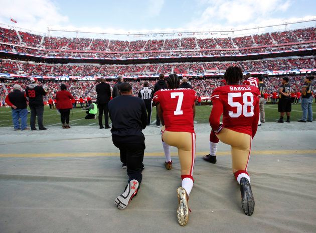 Eric Reid, Colin Kaepernick and Eli Harold of the San Francisco 49ers kneel on the sideline, during the anthem, prior to the game against the Seattle Seahawks at Levi Stadium on Jan. 1, 2017 in Santa Clara, Calif.