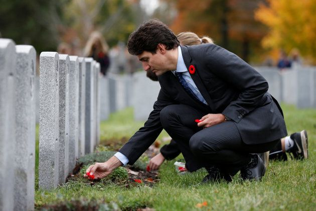 Canada's Prime Minister Justin Trudeau places a poppy at a grave during an event to mark the Veterans' Week at the National Military Cemetery in Ottawa, on Nov. 3, 2017.