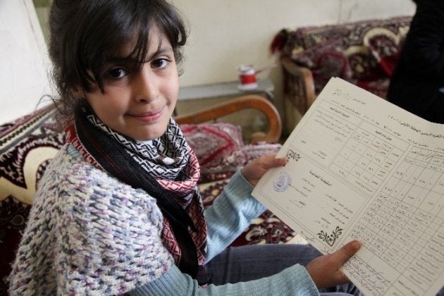 Jouri shows her last report card. Bekaa Valley, Lebanon, 2012.